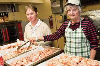 Volunteers at the St. Felix Centre prepare food for Out of the Cold clients in this file photo. The COVID restrictions the program had to abide by last year to shelter and feed the homeless will be in place again this year.
