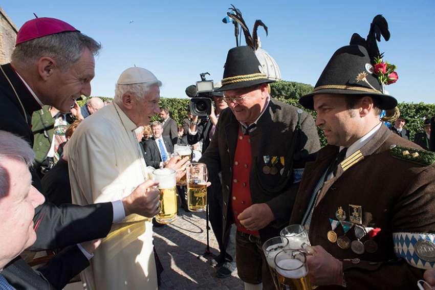 Retired Pope Benedict XVI and Archbishop Georg Ganswein, prefect of the papal household, left, toast men in traditional clothing with a beer during the German pontiff&#039;s 90th birthday celebration April 17 at the Vatican. The pope&#039;s birthday was the previous day. 