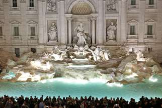  People gather in front of the landmark Trevi Fountain after its 2015 restoration in Rome. While millions of tourists throw a coin over their shoulder into the fountain hoping to return to Rome one day, the money scooped out of the fountain each week offers more concrete hope to the city&#039;s poor. 