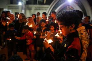 A boy holds a candle during an April 9 candlelight vigil for the victims of a bomb explosion at the Orthodox Church of St. George in Tanta, Egypt. Pope Francis said in a video message April 25 that he hopes his trip to Egypt will be a sign of friendship and peace.