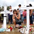 A woman prays at a memorial July 22 for victims behind the theater where a gunman opened fire on moviegoers in Aurora, Colo.