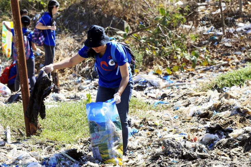 A volunteer picks up trash at Freedom Island, a marshland considered to be a sanctuary for birds, fish and mangroves in a coastal area of Las Pinas City, near Manila, Philippines, April 22, 2015. Catholic bishops in the Philippines criticized &quot;the continuing destruction of our common home&quot; and called for &quot;ecological conversion&quot; amid &quot;climate emergency.&quot;