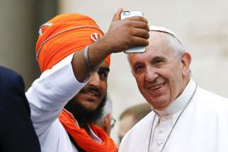 Pope Francis poses for a selfie with a member of the inter-religious community during his weekly audience in St. Peter&#039;s Square at the Vatican Oct. 28. 