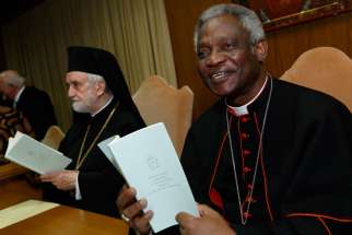 Cardinal Peter Turkson, president of the Pontifical Council for Justice and Peace, and Orthodox Metropolitan John of Pergamon, hold copies of Pope Francis&#039; encyclical on the environment before a news conference at the Vatican June 18. The encyclical is titled, &quot;Laudato Si&#039;, on Care for our Common Home.&quot; 