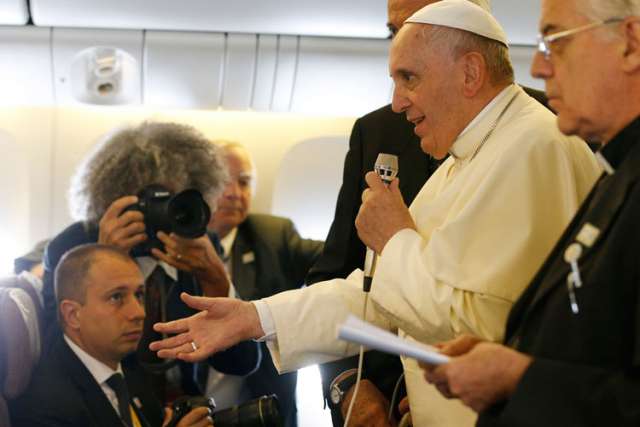 Pope Francis answers questions from journalists aboard the papal flight from Seoul, South Korea, to Rome Aug. 18.