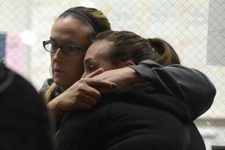 Evacuees from the scene of a shooting at the Inland Regional Center embrace Dec. 2 as they wait inside the Rudy C Hernandez Community Center in San Bernardino, Calif. At least 14 people were reported killed and more than a dozen injured when gunmen opened fire during a function at a center for people with developmental disabilities, police said.