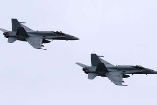 In this May 31, 2014, file photo, two Royal Canadian Air Force F-18 Hornet jets fly over Romania. Canada&#039;s new government has decided to stop airstrikes against Islamic State in the Middle East.