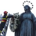 A firefighter places a wreath of flowers on a statue of Mary high atop a column at the Spanish Steps in Rome Dec. 8. The annual tradition marks the feast of the Immaculate Conception.