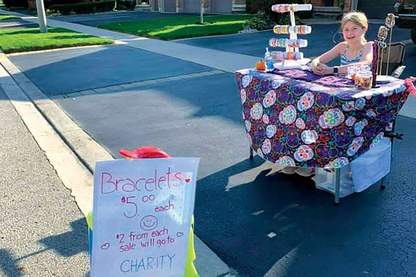 Ten-year-old Lauren Cutaia sells bracelets for charity at the end of her family’s driveway.