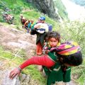 A woman carrying a child on her back climbs up a hill with other survivors during rescue operations in India’s mountainous Uttarakhand state June 23.