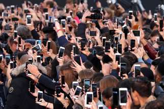 People use their smartphones to take photos in Paris, France, Oct. 1, 2017.