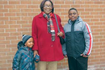 Magdalene Massicot and her grandsons pose in front of church in 2013. She died later that year.
