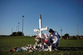 Joe Zevuloni weeps in front of a cross to commemorate the victims of the shooting at nearby Marjory Stoneman Douglas High School in Parkland, Fla. 