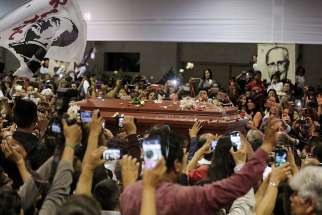 People react as the coffin holding the body of former Peruvian President Alan Garcia arrives at the APRA party headquarters April 18, a day after he died of a gunshot wound believed to be self-inflicted. 