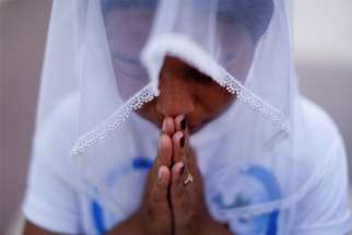 A woman is pictured in a file photo praying at St. Anthony church in Yangon, Myanmar.