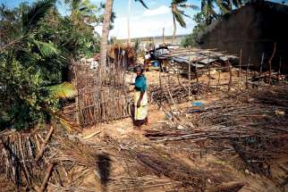 A woman in Ibo, Mozambique, stands outside a house damaged by Cyclone Kenneth May 1. Pope Francis will visit Mozambique on the first leg of a three-nation trip Sept. 4-10 that includes Madagascar and Mauritius.