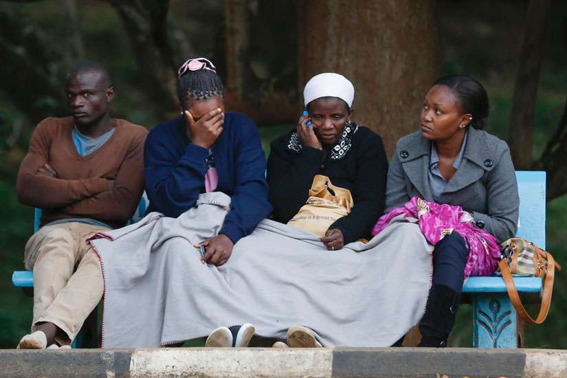 Wilson Kabwoya, Helen Akani, Agnes Khasandi and Margaret Naishorua wait for the bodies of their loved ones to arrive at a mortuary in Nairobi, Kenya, Dec. 2. Since Somali militants killed 36 non-Muslim quarry workers in early December, Christians in Keny a &quot;are living in fear, wondering where the next attack will be,&quot; said Bishop Emanuel Barbara of Malindi.