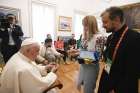 A young woman and a priest from Ukraine give Pope Francis shards from their war-torn country during a private meeting Aug. 3, 2023, at the Vatican nunciature in Lisbon, Portugal.