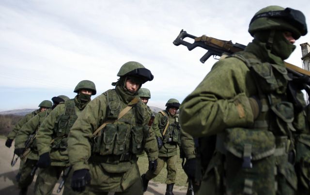 Armed men, believed to be Russian servicemen, march outside a Ukrainian military base in Crimea March 7. A Ukrainian Catholic priest in Crimea said church members are &quot;alarmed and frightened&quot; by the Russian military occupation and fear their communities could be outlawed again if Russian rule becomes permanent.