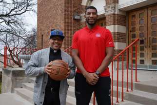 Detroit Pistons assistant coach Andrew Jones III, stands with Fr. John McKenzie outside Christ the King Church in Detroit, where Jones is taking OCIA classes and plans to a become Catholic during the Easter vigil.