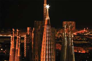 A general view shows a luminous star lit on a newly completed tower of the Basilica of the Holy Family.