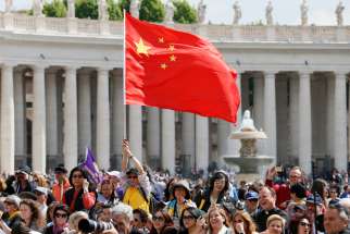 A man waves China&#039;s flag as Pope Francis leads his general audience in St. Peter&#039;s Square at the Vatican.