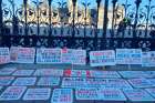 An assortment of protest signs are arranged in front of parliament hill in Ottawa at the 1 Million March 4 Children protest, Sept. 20, 2023.