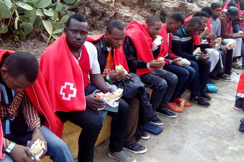 A group of migrants from sub-Saharan Africa cover themselves with blankets after being rescued off the coast of Ceuta in 2016. Catholic bishops from North Africa urged greater support for church life in their region, where migrants from sub-Saharan Africa now make up a large proportion of Catholic communities.