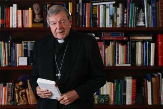 Australian Cardinal George Pell holds a copy of his book, &quot;Prison Journal,&quot; during an interview with Catholic News Service at his residence in Rome Dec. 18, 2020. Cardinal Pell talked to CNS about his new book, his time in prison and his plans for the future.