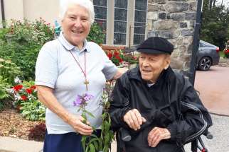 Fr. Leo Ramsperger alongside one of the sisters at St. Bernard’s accepting a plant from his Maynooth garden to plant at the residence.