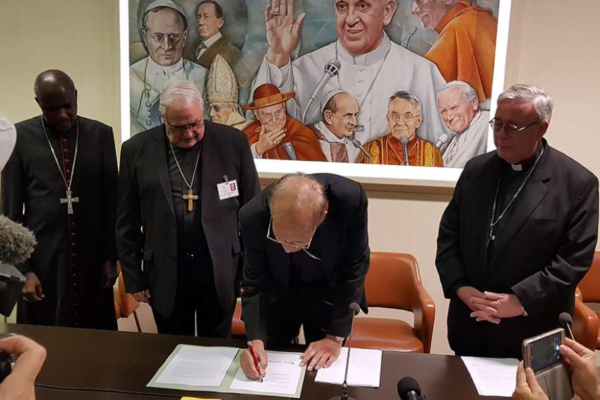  Cardinal Oswald Gracias of Mumbai, India, president of the Federation of Asian Bishops&#039; Conferences, signs a joint statement Oct. 26 at the Vatican&#039;s Sala Marconi calling on the international community to take immediate action against climate change. Also pictured in the signing are Archbishop Gabriel Mbilingi of Lubango, president of the Symposium of Episcopal Conferences of Africa and Madagascar, left, Cardinal Jose Luis Lacunza Maestrojuan of David, Panama, president of Latin American bishops&#039; council&#039;s economic committee, Archbishop Jean-Claude Hollerich, president of the Commission of the Bishops&#039; Conferences of the European Union, right.