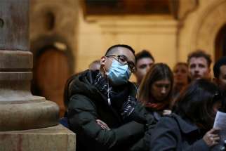 A man wears a protective mask during Mass at the Church of the Holy Sepulcher in Jerusalem&#039;s Old City March 1, 2020. With Holy Week celebrations closed to the public due to the coronavirus pandemic, Pope Francis postponed the traditional Good Friday collection for the Holy Land to September, the Vatican announced April 2.