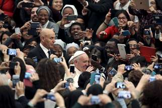 People take pictures with mobile phones and tablets as Pope Francis arrives at the Vatican on Nov. 21, 2015.