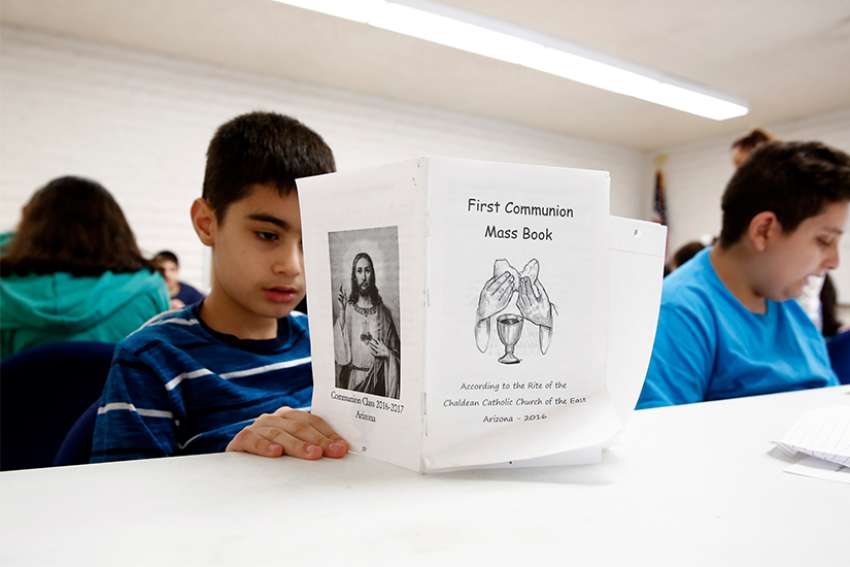 Children read about first Communion during a preparation class.