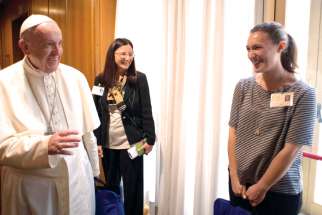 Pope Francis greets Emilie Callan, right, a synod delegate from Canada, during a session of the Synod of Bishops on young people, the faith and vocational discernment at the Vatican Oct. 11.