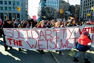 Solidarity banner leads thousands through downtown Toronto on Feb. 22 in a show of support for the Indigenous people protesting a B.C. gas pipeline.