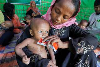 A woman from Myanmar feeds her child in a U.N. clinic for severely malnourished Rohingya children Oct. 28 in the Balukhali Refugee Camp near Cox&#039;s Bazar, Bangladesh. More than 600,000 Rohingya have fled government-sanctioned violence in Myanmar for safety in Bangladesh.