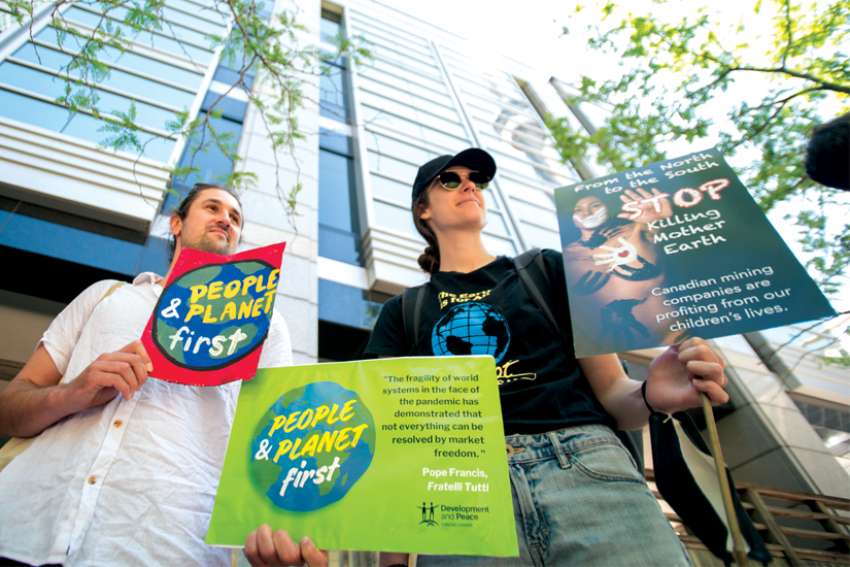 Development and Peace - Caritas Canada member Emily Briggson, right, joins a protest outside the Prospectors and Developers Association of Canada convention June 13 in Toronto.