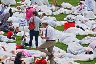 Demonstrators step into white garbage bags June 1 on Parliament Hill to represent the body bags that will result from euthanasia and assisted suicide. Hundreds gathered in Ottawa to protest against Bill C-14.