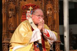Cardinal Timothy M. Dolan of New York presides at an August Mass at St. Patrick&#039;s Cathedral in New York. The Archdiocese of New York announced it will close more than 30 by August 2015 as part of a reorganization initiative that will merge 116 parishes i nto 56.