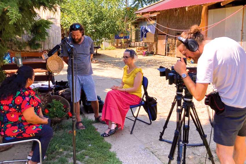 Laura Ieraci interviews a gypsy lady in her yard for an upcoming documentary on the faith of Hungarian gypsies.