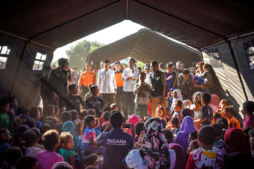  Indonesian President Joko Widodo, center, talks to earthquake victims inside a tent shelter July 30 on the island of Lombok in Indonesia. At least 16 people were killed and hundreds injured July 29 in the magnitude 6.4 earthquake. 