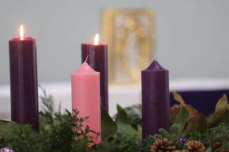 Candles and the Book of the Gospels are pictured during Mass on the second week of Advent at Jesus the Divine Word Church in Huntington, Md., Dec. 5, 2021.