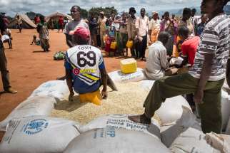 Refugees wait for food rations from the United Nations in early February at a camp in Mwanza, Malawi. In Malawi, where 40 percent of the population needs food aid, the country’s bishops have called for international help to avert a crisis.