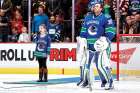 Elizabeth Irving sings the Canadian anthem next to Vancouver Canuck netminder Ryan Miller before a game in 2016.