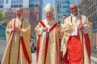 Cardinal Thomas Collins walks with newly-ordained priests, Fr. David Twaddle (left) and Fr. Ricardo Davis outside St. Michael’s Cathedral in Toronto following an ordination ceremony May 9.