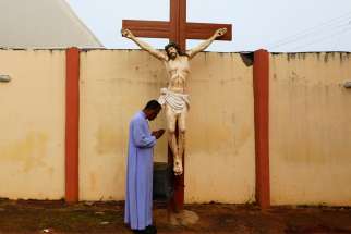 Father Paul Obayi prays in front of the crucifix at St. Mary&#039;s Cathedral in Enugu, Nigeria, Sept. 30, 2021. Catholic churches in Sokoto, Nigeria, suspended Masses May 15, 2022, after the government imposed a curfew to quell protests after arrests in the mob death of a college student.