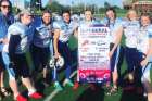 Members of the St. Benedict’s Bears girls’ football team with a pennant marking the first ever girls tackle football game to be played in Canada.