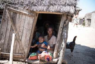 A family sits inside their hut in Ambovombe, Madagascar, Sept. 22, 2015. Hunger levels are now so severe in drought-ridden southern Madagascar that many people in remote villages have eaten almost nothing but cactus fruit for up to four years, said a Catholic Relief Services official.
