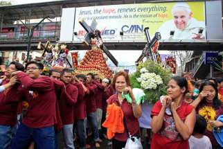 Men and women carrying replica statues of the Black Nazarene walk under a banner of Pope Francis during a procession in Manila, Philippines, Jan. 7. Millions of devotees are expected to attend the annual procession of the Black Nazarene Jan. 9. The Black Nazarene, a life-size wooden statue of Christ carved in Mexico and brought to the Philippines in the 17th century, is believed to have healing powers in the predominantly Catholic country.